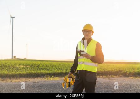 Ingegnere con tablet digitale controlla le turbine eoliche. Foto Stock