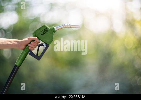 Mano con ugello di rifornimento verde con la scritta BIO. Foto Stock