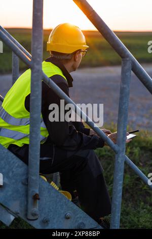 Ingegnere con tablet digitale controlla le turbine eoliche. Foto Stock