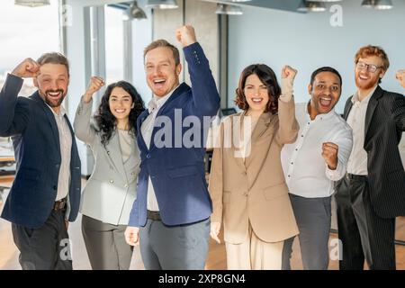 Felice team aziendale diversificato che celebra il successo in Modern Office Foto Stock