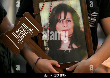 Beirut, Beirut, Libano. 4 agosto 2024. Un pianto tiene una foto di sua madre, vittima dell'esplosione del porto di Beirut del 4 agosto 2024, durante una marcia per celebrare il 4° anniversario dell'esplosione che ha ucciso più di 200 persone e ferito più di 6.000 persone. L'esplosione del porto di domenica arriva mentre la regione si prepara a ritorsioni dopo che uno sciopero israeliano ha ucciso un comandante di Hezbollah a Beirut e un'esplosione a Teheran, ampiamente accusata di Israele, ha ucciso il leader di Hamas Ismail Haniyeh. (Credit Image: © Marwan Naamani/ZUMA Press Wire) SOLO PER USO EDITORIALE! Non per USO commerciale! Foto Stock