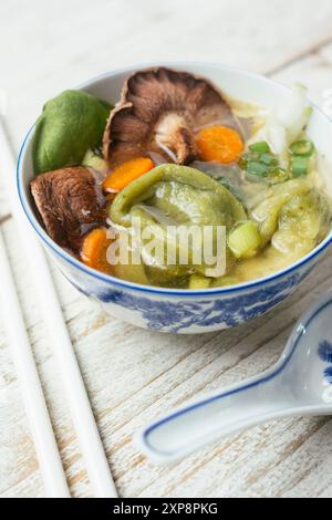Zuppa di wonton di spinaci vegani fatta in casa con funghi shiitake Foto Stock