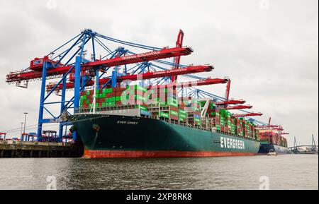 PRODUZIONE - 26 luglio 2024, Amburgo: Il container cargo Ever Greet è ormeggiato a Waltershofer Hafen presso il Container Terminal Burchardkai (CTB) della Hamburger Hafen und Logistik AG (HHLA). Foto: Christian Charisius/dpa Foto Stock