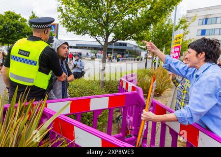 Rotherham, Regno Unito. 04 AGOSTO 2024. I manifestanti da entrambe le parti si scontrano mentre centinaia di poliziotti e manifestanti si scontrano fuori da un Holiday Inn Express a Manvers Way, Rotherham. I manifestanti di destra, descritti da Sir Kier Starmer come "delinquenti", hanno dato fuoco alla proprietà, hanno distrutto il vetro e hanno combattuto con la polizia per diverse ore. Arresti multipli e feriti a rivoltosi e polizia. Credito Milo Chandler/Alamy Live News Foto Stock