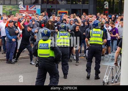 Rotherham, Regno Unito. 04 AGOSTO 2024. Centinaia di poliziotti e manifestanti si scontrano fuori da un Holiday Inn Express a Manvers Way, Rotherham. I manifestanti di destra, descritti da Sir Kier Starmer come "delinquenti", hanno dato fuoco alla proprietà, hanno distrutto il vetro e hanno combattuto con la polizia per diverse ore. Arresti multipli e feriti a rivoltosi e polizia. Un piccolo contigente SUTR che è venuto a sostenere i migranti è stato rimosso dalla polizia per la loro sicurezza. Credito Milo Chandler/Alamy Live News Foto Stock