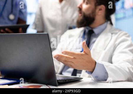 Medico autorizzato che esamina i risultati dei test e le cartelle cliniche durante la riunione del gabinetto, lavorando per trovare la migliore opzione di diagnosi e trattamento. Medico che esamina i raggi X con i suoi colleghi. Primo piano. Foto Stock