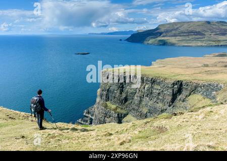 Un camminatore che si avvicina al Loch Eynort sulla cima della scogliera costiera cammina sotto Beinn an Eòin sul lato nord di Glen Brittle, Isola di Skye, Scozia, Regno Unito Foto Stock