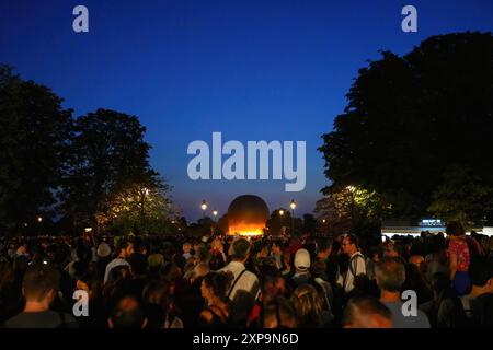 Parigi, Francia - 2 agosto 2024 : la folla si è riunita nei Giardini delle Tuileries per guardare il volo della fiamma olimpica legata al pallone al tramonto durante il P Foto Stock