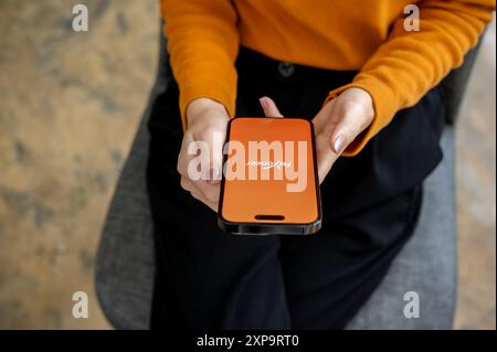 Chiang mai, Thailandia - 1 agosto 2024: Immagine ravvicinata di una donna seduta al chiuso e che utilizza l'app Payoneer sul suo iPhone. Il logo dell'app Payoneer su un s Foto Stock