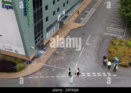 NOTA PER I REDATTORI: LINGUA A GRAFFITTI SUL MURO Una vista droni della polizia all'Holiday Inn Express di Tamworth, Staffordshire, dopo che una folla l'ha aggredita domenica in quello che la polizia ha detto sono stati "atti violenti di teppisti". Un grande gruppo di individui è stato visto nell'area della città di Staffordshire, con persone viste lanciare proiettili, frantumare finestre, accendere incendi e colpire la polizia. Data foto: Lunedì 5 agosto 2024. Foto Stock