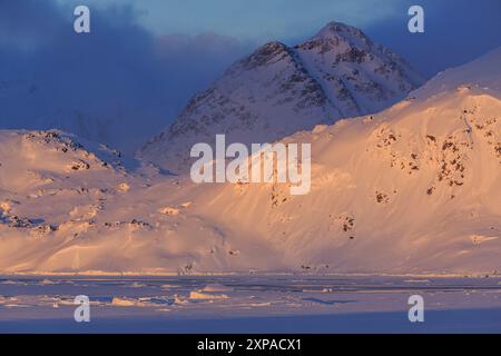 Luce serale sulle ripide montagne in inverno, Kulusuk, Groenlandia orientale, Groenlandia Foto Stock