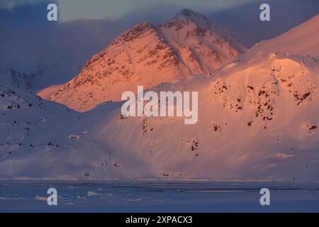 Luce serale sulle ripide montagne in inverno, Kulusuk, Groenlandia orientale, Groenlandia Foto Stock