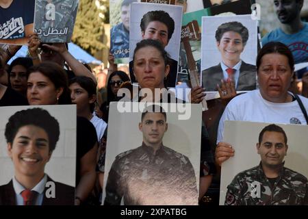 Beirut, Libano. 4 agosto 2024. La gente tiene ritratti delle vittime in commemorazione del quarto anniversario delle esplosioni portuali di Beirut del 2020 a Beirut, Libano, 4 agosto 2024. Le famiglie delle vittime dei mortali bombardamenti del porto di Beirut del 2020 hanno commemorato il quarto anniversario dell'incidente di domenica con due marce nel centro di Beirut e un raduno di fronte ai silos del porto. Diverse famiglie hanno tenuto discorsi che sottolineavano la necessità di completare l'indagine, emettere un atto d'accusa nel caso e nominare i responsabili delle esplosioni. Crediti: Bilal Jawich/Xinhua/Alamy Live News Foto Stock