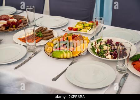 Tavolo festivo con insalate Caesar, barbabietole, piatto di frutta senza persone Foto Stock