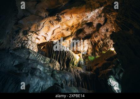 intricate formazioni di stalattiti e stalagmiti in una grotta di pietra calcarea panoramica, illuminata dalla luce naturale, che mostra la bellezza del geo sotterraneo Foto Stock