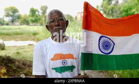 Bambini con membri della famiglia che indossano maglietta con logo bandiera indiana e che tengono in mano, sventolano o corrono con il tricolore con verde sullo sfondo, celebr Foto Stock