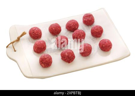 Polpette su una tavola in ceramica isolata su sfondo bianco. Carne cruda per cucinare. Carne per barbecue. Foto Stock
