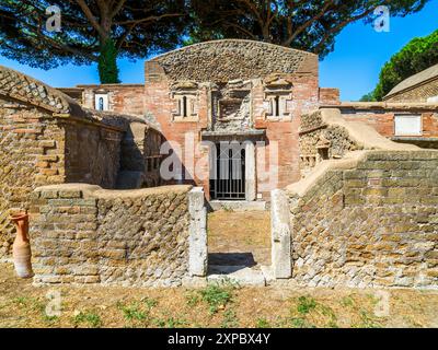 Edificio sepolcrale di una o due piani, spesso circondato da un recinto; soffitti a botte o tetti piatti; facciate in mattoni adornate con timpani triangolari, plinti, lesbiche, colonne e capitelli; piccole finestre e porte incorniciate da soglie in travertino, stipiti ed epistoli. La necropoli si sviluppò ai lati della via Flavia tra la fine del i e il IV secolo d.C. - Necropoli di Portus nell'Isola Sacra, Fiumicino, Roma, Italia Foto Stock