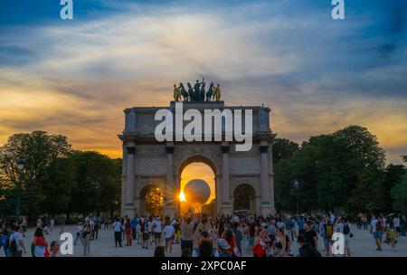 Parigi, Francia. 4 agosto 2024. I visitatori scattano foto della mongolfiera che porta il calderone olimpico illuminato al tramonto vicino all'Arco di Trionfo del Carrousel a Parigi, Francia, 4 agosto 2024. Crediti: Li GA/Xinhua/Alamy Live News Foto Stock