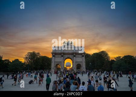 Parigi, Francia. 4 agosto 2024. I visitatori guardano la mongolfiera che porta il calderone olimpico illuminato durante il tramonto vicino all'Arco di Trionfo del Carrousel a Parigi, Francia, 4 agosto 2024. Crediti: Li GA/Xinhua/Alamy Live News Foto Stock