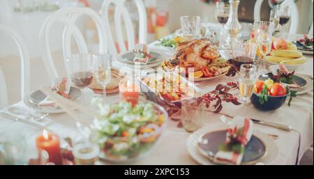 Foto senza persone con un bellissimo tavolo di Natale con un piatto di tacchino arrosto, cornici di verdure, patate al forno, insalate, elementi decorativi e CandleLights Foto Stock