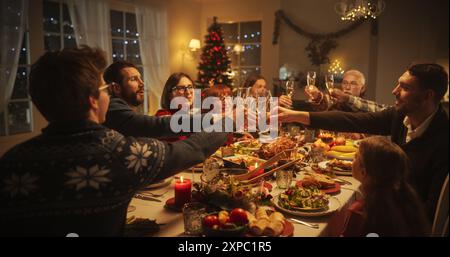 Cena di Natale con genitori, bambini e amici felici a casa. Primo piano di bicchieri di champagne e brinetti, festeggiando una vacanza con un delizioso pasto di tacchino in serata Foto Stock