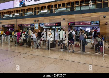 BERLINO, GERMANIA - 3 AGOSTO 2024: Persone in fila al controllo di sicurezza dell'aeroporto internazionale di Berlino-Brandeburgo. Persone in piedi sulla linea A. Foto Stock