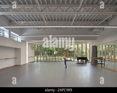 Interni dello studio con ballerino, pianoforte e finestrazioni. Rambert School of Ballet, Londra, Regno Unito. Architetto: MICA, 2023. Foto Stock