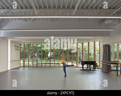 Interni dello studio con ballerino, pianoforte e finestrazioni. Rambert School of Ballet, Londra, Regno Unito. Architetto: MICA, 2023. Foto Stock