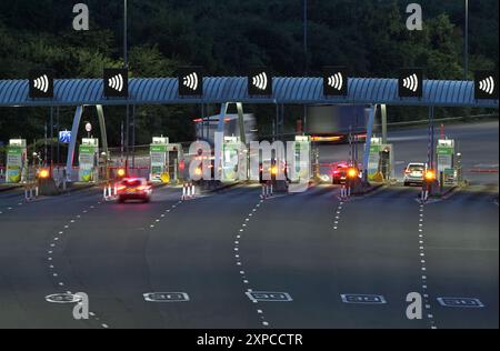 Caselli sull'autostrada M6 a pedaggio in direzione nord vicino a Great Wyrley, Staffordshire, di notte. Foto Stock