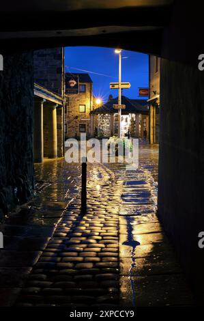 Una serata umida a Skipton, nel North Yorkshire. Guardando attraverso un arco da Sheep Street a Victoria Square. Foto Stock