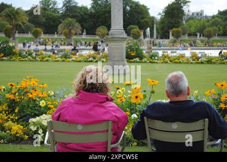 Una coppia anziana seduta sul parco a guardare il giardino di Parigi. Foto Stock