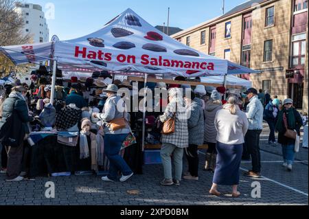 Una bancarella che vende una varietà di cappelli in un mercato settimanale che si tiene il sabato lungo Salamanca Place a Hobart, Tasmania, Australia. Salamanca era pr Foto Stock