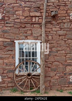 Ruota in legno appoggiata sul davanzale della finestra nella parete in pietra dell'Hubbell Trading Post Foto Stock