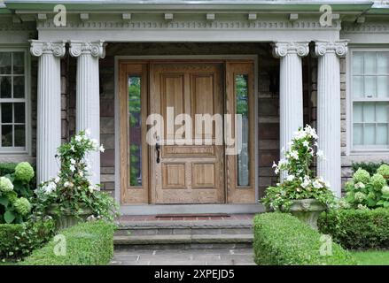 Porta anteriore in legno con colonne di stile classico Foto Stock