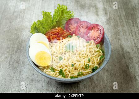 Una ciotola di spaghetti istantanei con uova, pomodori e lattuga Foto Stock