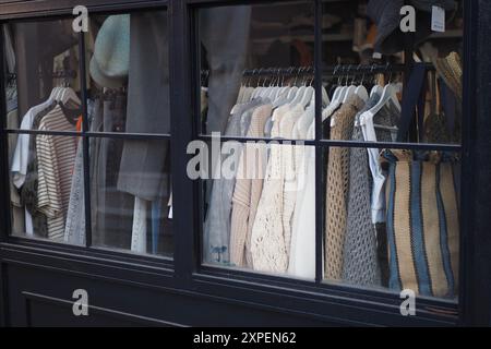 Un'elegante esposizione di vari capi alla moda esposti elegantemente in una finestra Boutique Foto Stock