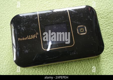 Terengganu, Malesia - 23 agosto 2024 : primo piano di wifi tascabile nero OEM modificato su sfondo verde. Piccolo e portatile. Foto Stock