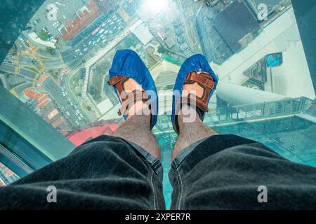 Guardando in basso attraverso un pavimento di vetro, parte della passeggiata arcobaleno a 'The Top', Kontar Tower, George Town, Penang, Malesia Foto Stock