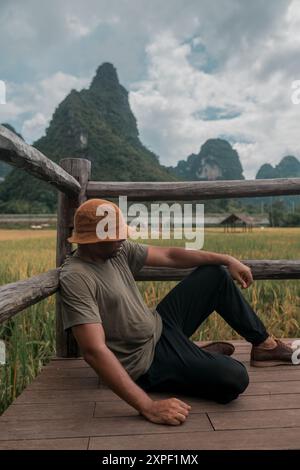 Un viaggiatore stanco si prende qualche momento per riposarsi dopo aver esplorato la città di Chongzuo, nella provincia cinese del Guangxi. Foto Stock