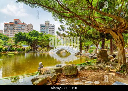 Meraviglioso giardino verde e panoramico ponte bianco sul lago, Taipei Foto Stock