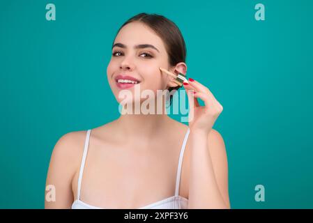 Crema idratante per collagene con siero contagocce. Beauty Woman che gocciola siero idratante dalla pipetta sul viso durante la procedura di bellezza in studio. Protezione del siero Foto Stock