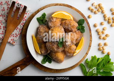 Deliziose frittelle spagnole tradizionali. Tavolo decorato con decorazioni natalizie. Foto Stock