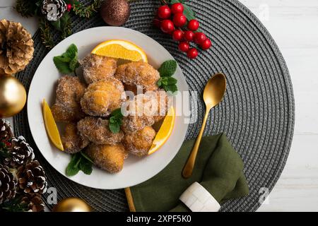 Deliziose frittelle spagnole tradizionali. Tavolo decorato con decorazioni natalizie. Foto Stock