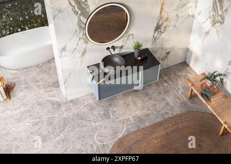 Vista dall'alto del bagno moderno di lusso, pareti in marmo bianco, vasca, pavimento grigio, piante interne, panorama. Foto Stock