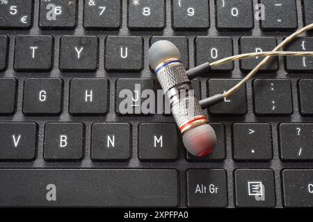 Terengganu, Malesia - 23 agosto 2024 : primo piano delle cuffie cablate su un laptop grigio con tastiera Foto Stock