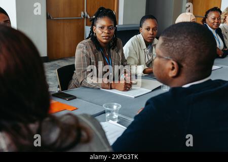 Colleghi diversi hanno partecipato a una discussione in una sala conferenze, mostrando il lavoro di squadra e la collaborazione. Ideale per aziende, uffici e aziende Foto Stock