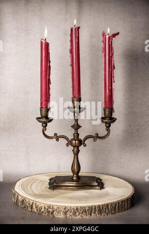 Candela accesa con candelabro rosso Foto Stock