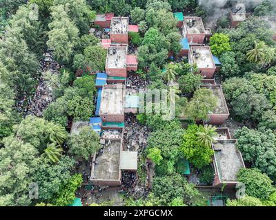 (NOTA PER I REDATTORI: Immagine scattata con un drone) una vista aerea mostra manifestanti anti-governativi che marciano sulla strada di fronte al posto del primo ministro Sheikh Hasina durante la celebrazione. Migliaia di persone del Bangladesh celebrano le dimissioni del primo ministro del Bangladesh Sheikh Hasina. Le proteste in Bangladesh iniziate a luglio per l'abolizione del sistema di quote nei posti di lavoro governativi culminarono il 5 agosto, quando il capo militare del Bangladesh il generale Waker-uz-Zaman annunciò un governo di transizione dopo che il primo ministro Sheikh Hasina era fuggito dal paese a causa di violente proteste a livello nazionale. Centinaia di persone noi Foto Stock