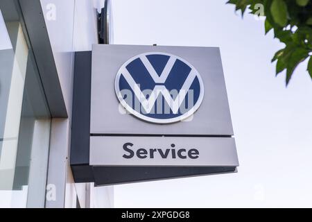 Torrevieja, Spagna - 09-07-2024: Logo Volkswagen in cima a un centro di assistenza, catturato contro il cielo limpido. Cartello VW. Perfetto per contenuti relativi al settore automobilistico Foto Stock